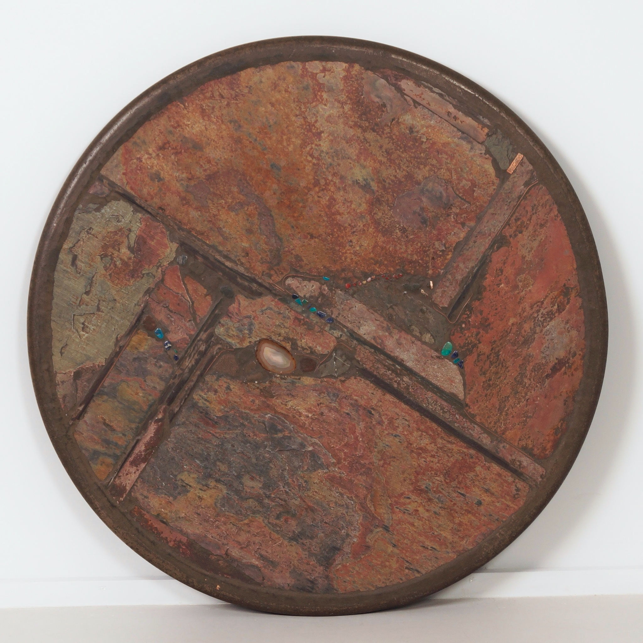 Ronde salontafel van Paul Kingma uit 1990 in aardse tinten met inleg van halfedelstenen